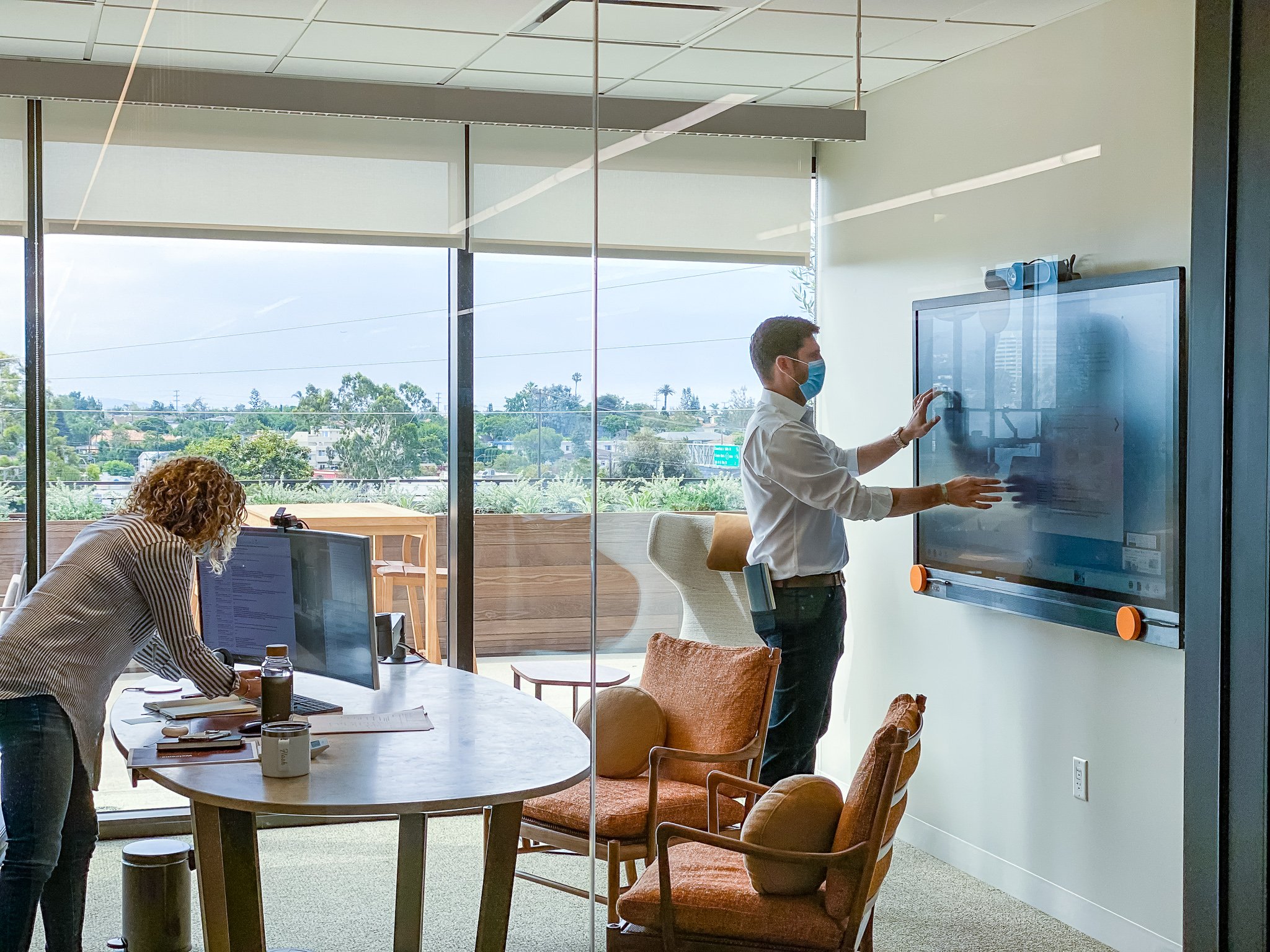 Two researchers collaborate in the Ellison Institute of Technology on a ThinkHub touchscreen display