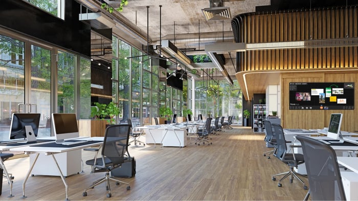 Large open office space with screens in the background with T1V software